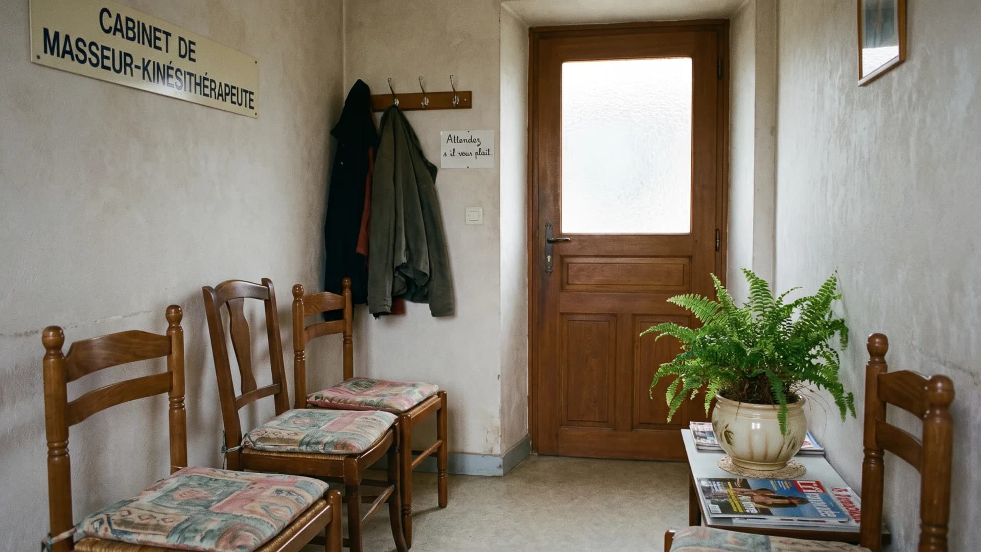 Salle d’attente d’un cabinet de masseur-kinésithérapeute : chaises, plante, porte dépolie
